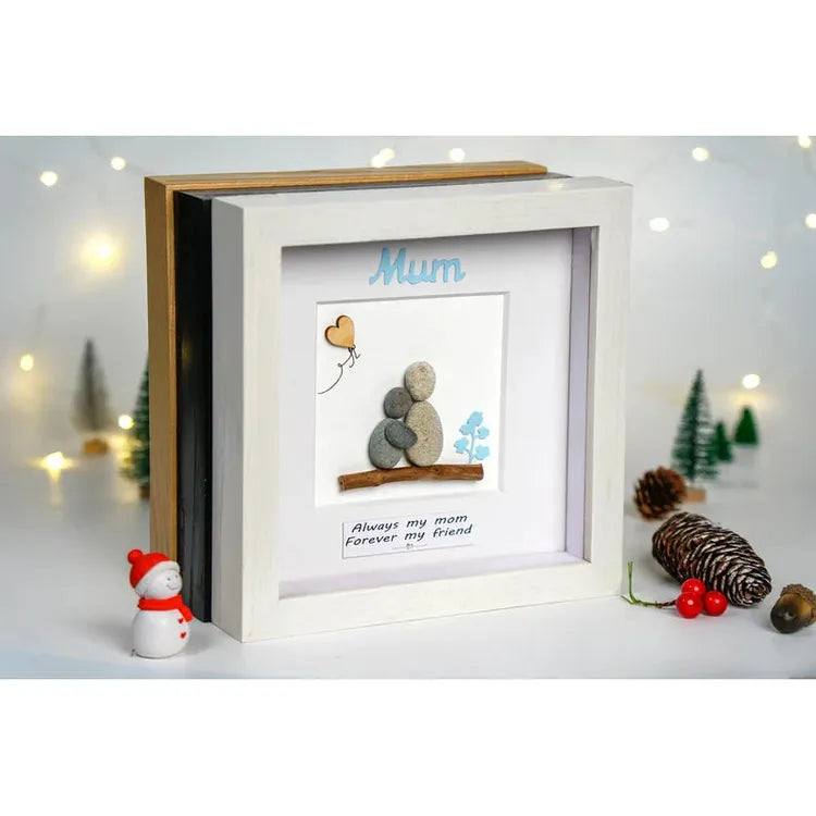 Handmade Pebble Art Children Embracing Mother Inside a Snowy Floral Scene by Dovaart.com